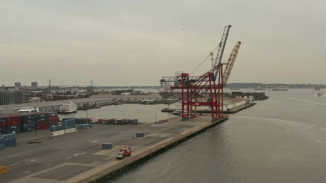 Wide view of a port with a red container crane and quay