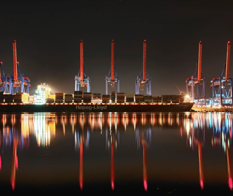Container ship under illuminated gantry cranes at Altenwerder terminal, Port of Hamburg